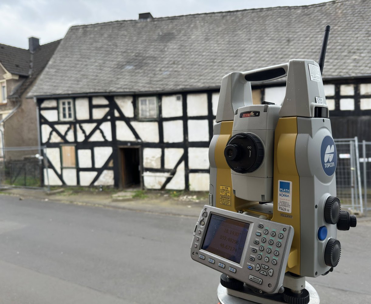 Tachymeter vor historischem Fachwerkgebaeude